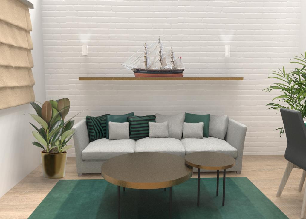 Jasny salon z szarą sofą, zielonymi poduszkami, okrągłymi stolikami kawowymi i modelem żaglowca na półce nad sofą.