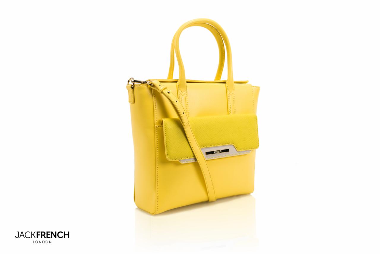 Żółta skórzana torebka Jack French London z krótkimi uchwytami i odpinanym paskiem na ramię, na białym tle z delikatnym odbiciem.