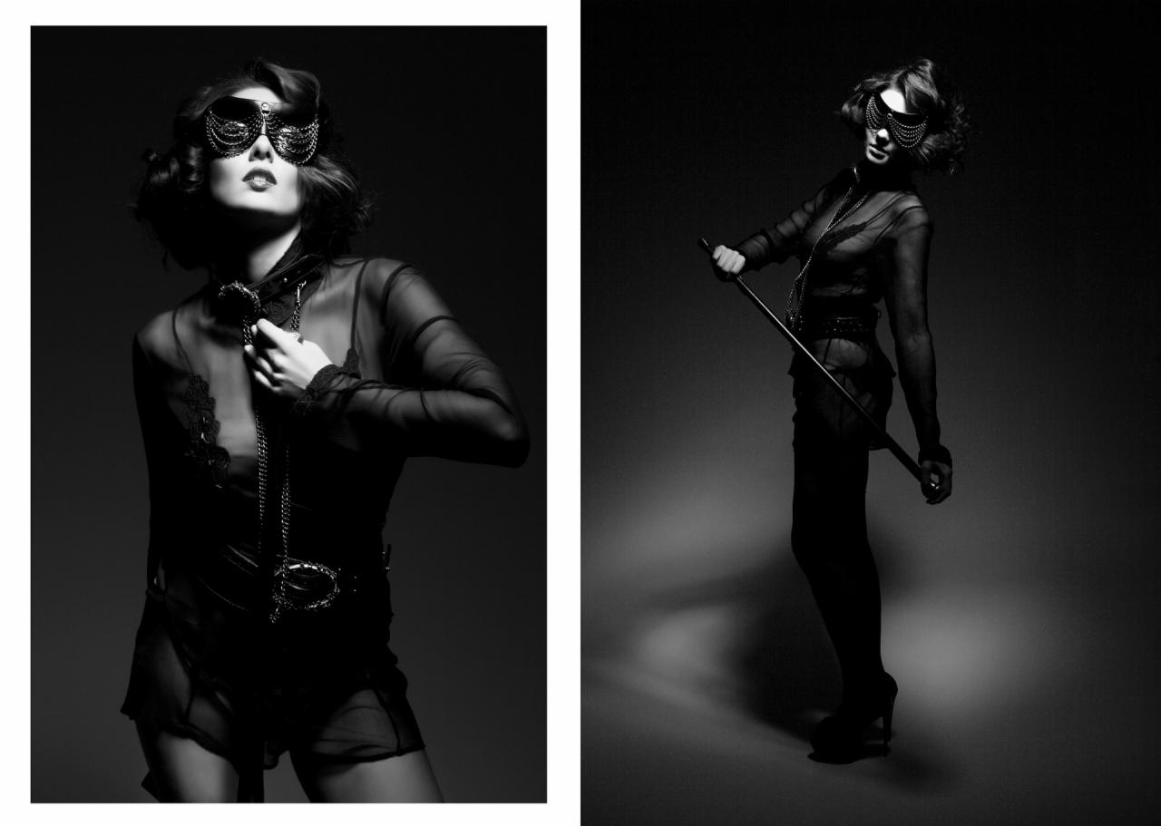 Czarno-białe zdjęcie kobiety w stylizowanej sesji, z maską na twarzy i rekwizytami, w półmroku.