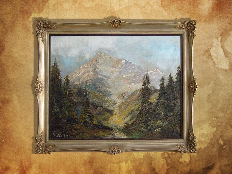 Obraz olejny przedstawiający górski krajobraz z lasem iglastym i strumieniem, oprawiony w ozdobną, srebrną ramę w stylu vintage, na tle teksturowanej ściany.