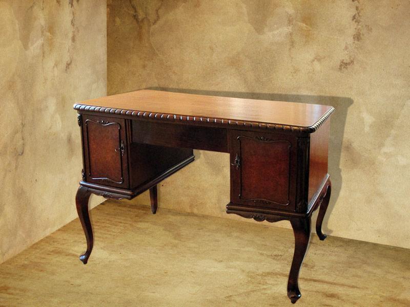 Antyczne biurko z ciemnego drewna z dwoma szafkami po bokach i jasnym blatem, ustawione w rogu pokoju z teksturowanymi ścianami.