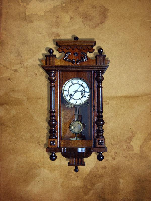 Antyczny, wiszący zegar z ciemnego drewna z wahadłem, tarcza z rzymskimi cyframi, na tle ściany z plamami.