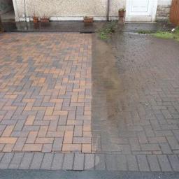 Mobilna Myjnia Mycie Pełną Parą - Częściowo umyta kostka brukowa na podjeździe przed domem, widoczna wyraźna różnica w kolorze i czystości między umytą a nieumytą powierzchnią.