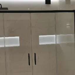 Nowoczesna kabina prysznicowa z czarnymi profilami i deszczownicą, wykończona płytkami imitującymi marmur z podświetlonymi wnękami.