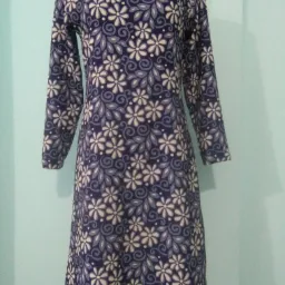 Sukienka z długim rękawem w kwiatowy wzór, uszyta w Kościerzynie, prezentowana na manekinie.