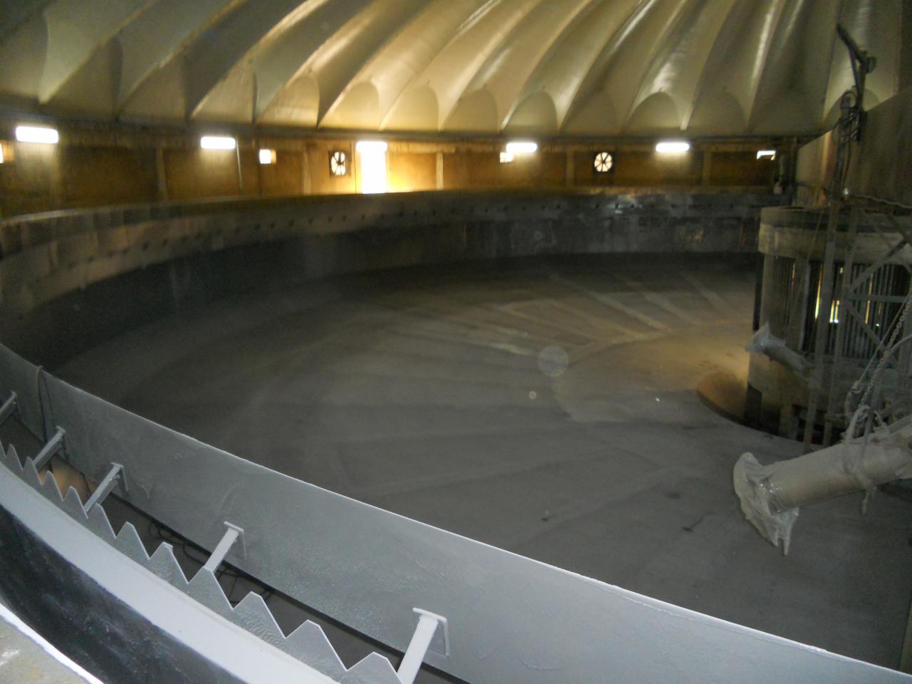 Wnętrze kopuły z nałożoną warstwą szarej pianki PUR, widoczne dysze natryskowe i nieregularna struktura powierzchni.