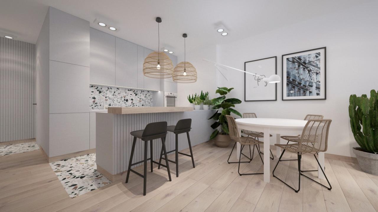 Jasne wnętrze mieszkania z drewnianą podłogą, wyspą kuchenną z hokerami, okrągłym stołem i rattanowymi lampami wiszącymi.