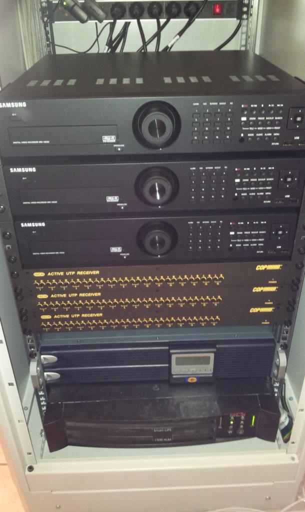 Szafa rack z zamontowanymi rejestratorami Samsung DVR-1620, aktywnymi odbiornikami UTP i zasilaczem awaryjnym Smart-UPS 1500 XLM.