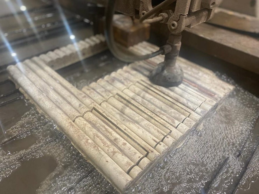 Cięcie wodą rurek ceramicznych na stole roboczym, widoczne dysza tnąca i woda chłodząca.