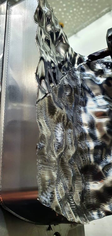 Detale powierzchni metalowego elementu po obróbce, widoczne ślady po narzędziu.