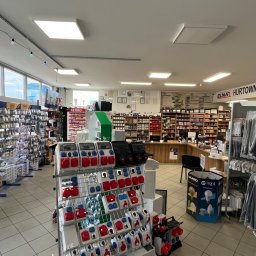 Hurtownia Elektryczna ELNAR Mariusz Bartosiak - Wnętrze sklepu elektrycznego: regały pełne akcesoriów, gniazda, wtyczki, kable. Widoczny napis 'ELNAR Hurtownia Elektryczna'. Jasne oświetlenie, czyste wnętrze.