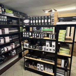 Hurtownia Elektryczna ELNAR Mariusz Bartosiak - Oświetlenie LED na półkach sklepowych: lampy sufitowe, panele, reflektory. Różne modele i marki, np. Milagro, E-light, Tokyo. Apteczka na ścianie w tle.