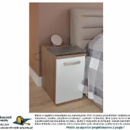 Szafka nocna z białym frontem i drewnopodobnym korpusem, z laptopem i routerem na blacie, ustawiona obok łóżka z szarym zagłówkiem w sypialni.