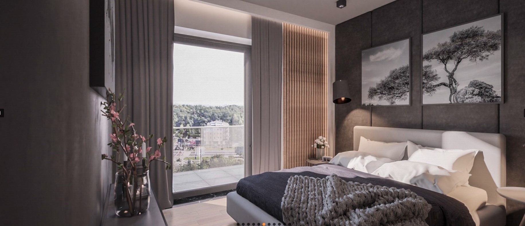 Nowoczesna sypialnia z łóżkiem w odcieniach szarości, widokiem na miasto z balkonu i dekoracjami w postaci grafik drzew oraz wazonu z kwiatami.