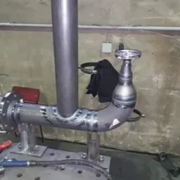 Spawanie rur w warsztacie w Kamiennej Górze, widoczne świeże spawy na metalowej konstrukcji, na stole spawalniczym leży spawarka.