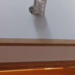 DmRem - Niedokończone malowanie ściany z widocznym gniazdkiem elektrycznym i drewnianą listwą przypodłogową w dolnej części kadru.