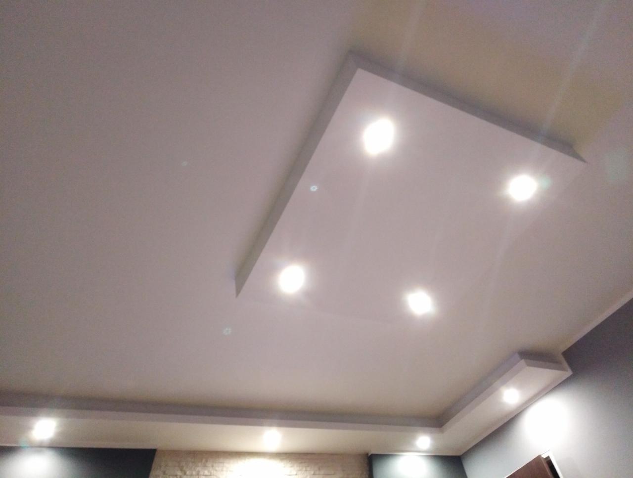 Podwieszany sufit z wbudowanym oświetleniem punktowym, widok z dołu na wykończone wnętrze.