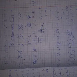 Otwarty zeszyt w kratkę z ręcznie rozwiązywanymi zadaniami z matematyki, zapisany niebieskim długopisem.