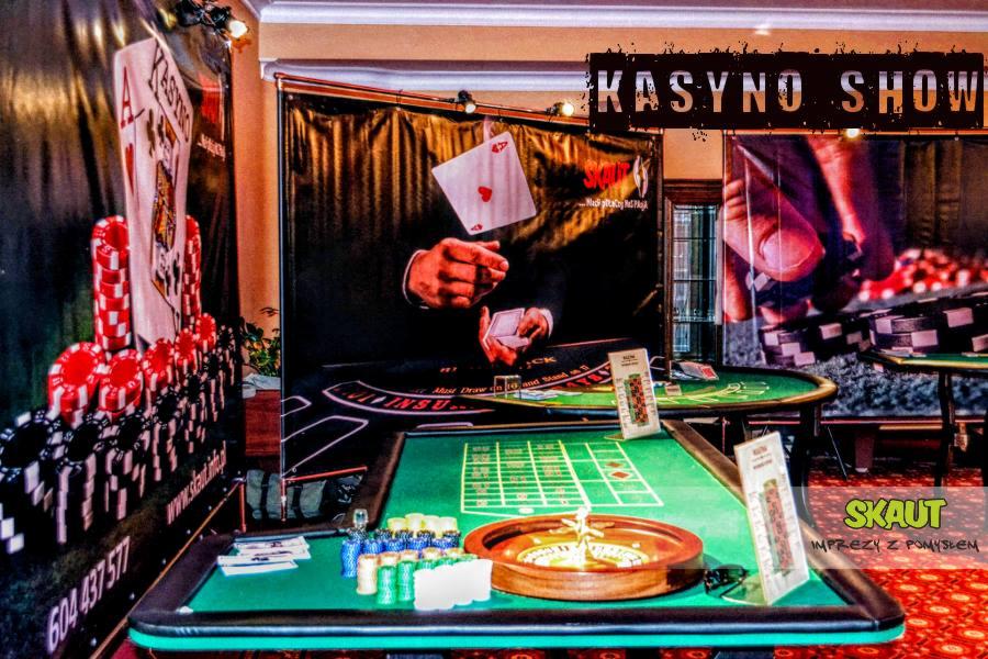 Aranżacja przestrzeni z stołami do gier kasynowych, żetonami, kołem ruletki i dekoracjami tematycznymi.