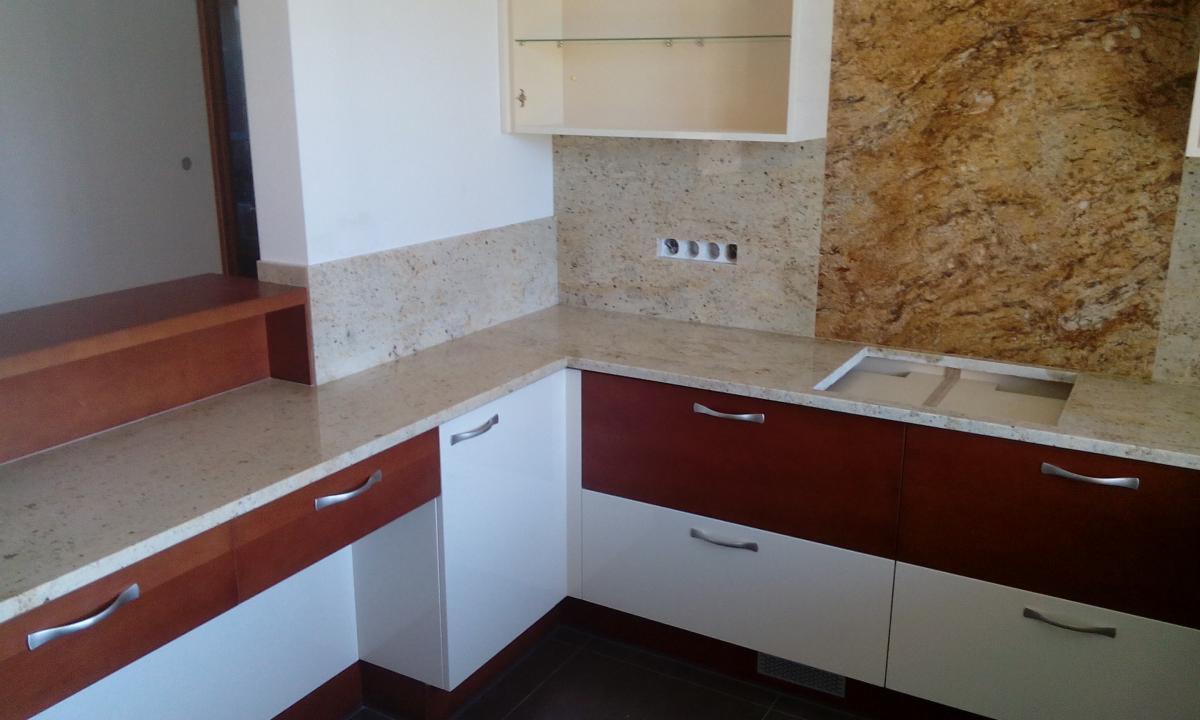 Nowoczesna kuchnia z blatem o jasnym, nakrapianym wzorze, brązowo-białe szafki z podłużnymi, metalowymi uchwytami, oraz pasujący backsplash i ściana w odcieniach brązu i beżu, z widocznymi...