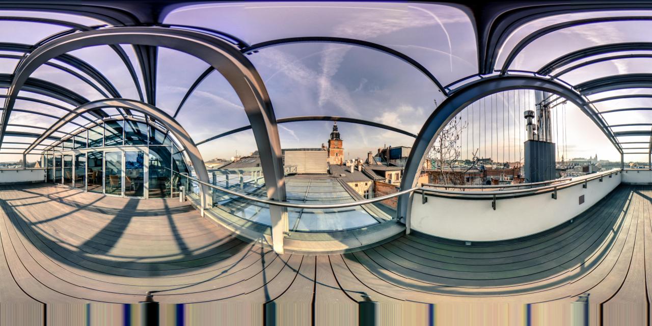 Panorama sferyczna HDR+ z widokiem na Kraków z przeszklonego dachu z metalową konstrukcją, w tle budynki Starego Miasta i wieża kościoła Mariackiego.