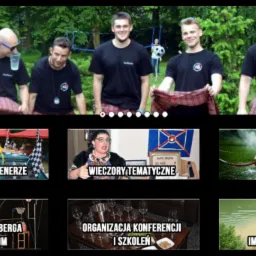 Grupa mężczyzn w czarnych koszulkach i szkockich kiltach prezentuje się na tle zieleni, prawdopodobnie podczas integracji firmowej.