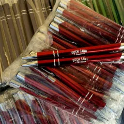 Zestaw zapakowanych długopisów w kolorach brązowym, czerwonym i czarnym, z czego dwa czerwone długopisy na wierzchu posiadają nadruk 'DUCH SANU z Bachórza'.