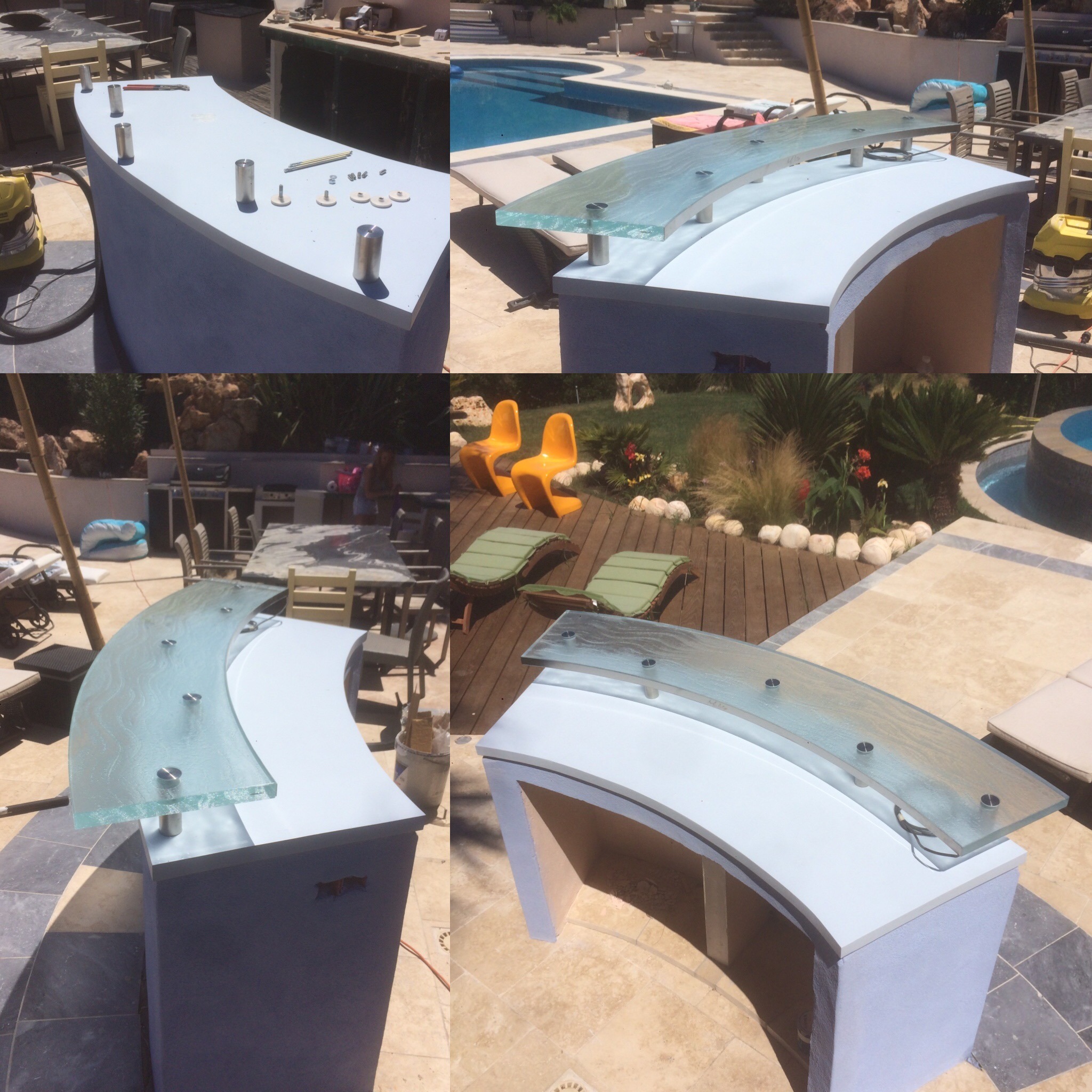 Budowa baru zewnętrznego z zakrzywionym blatem i szklaną nadstawką, na tle basenu i ogrodu.