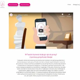 Animowana prezentacja aplikacji mobilnej Akolja z interfejsem wyświetlanym na smartfonie, obok stylizowana rzeźba antyczna i elementy biurowe na stole.