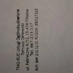 Dane kontaktowe firmy TMG-BUD Usługi Ogólnobudowlane Tomasz Orłowski, adres, telefon, NIP i REGON na białym tle, tekst w orientacji pionowej, lekko zamazany.