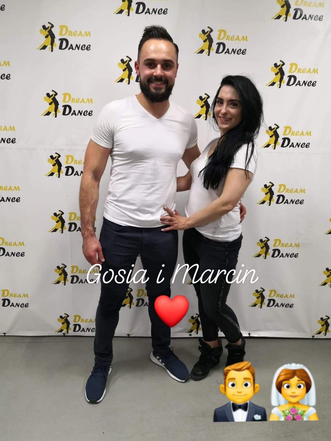 Uśmiechnięta para instruktorów, Gosia i Marcin, na tle ściany z powtarzającym się logo 'Dream Dance', z dodanymi emotikonami serca i pary młodej.