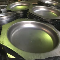 Stos metalowych, ośmiokątnych miseczek z przetłoczeniem, surowe wykończenie, widoczne ślady obróbki.