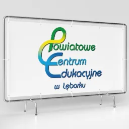 Projekt logo Powiatowego Centrum Edukacyjnego w Lęborku, umieszczony na banerze reklamowym z metalowym stelażem. Logo w kolorach zielonym, żółtym i niebieskim.