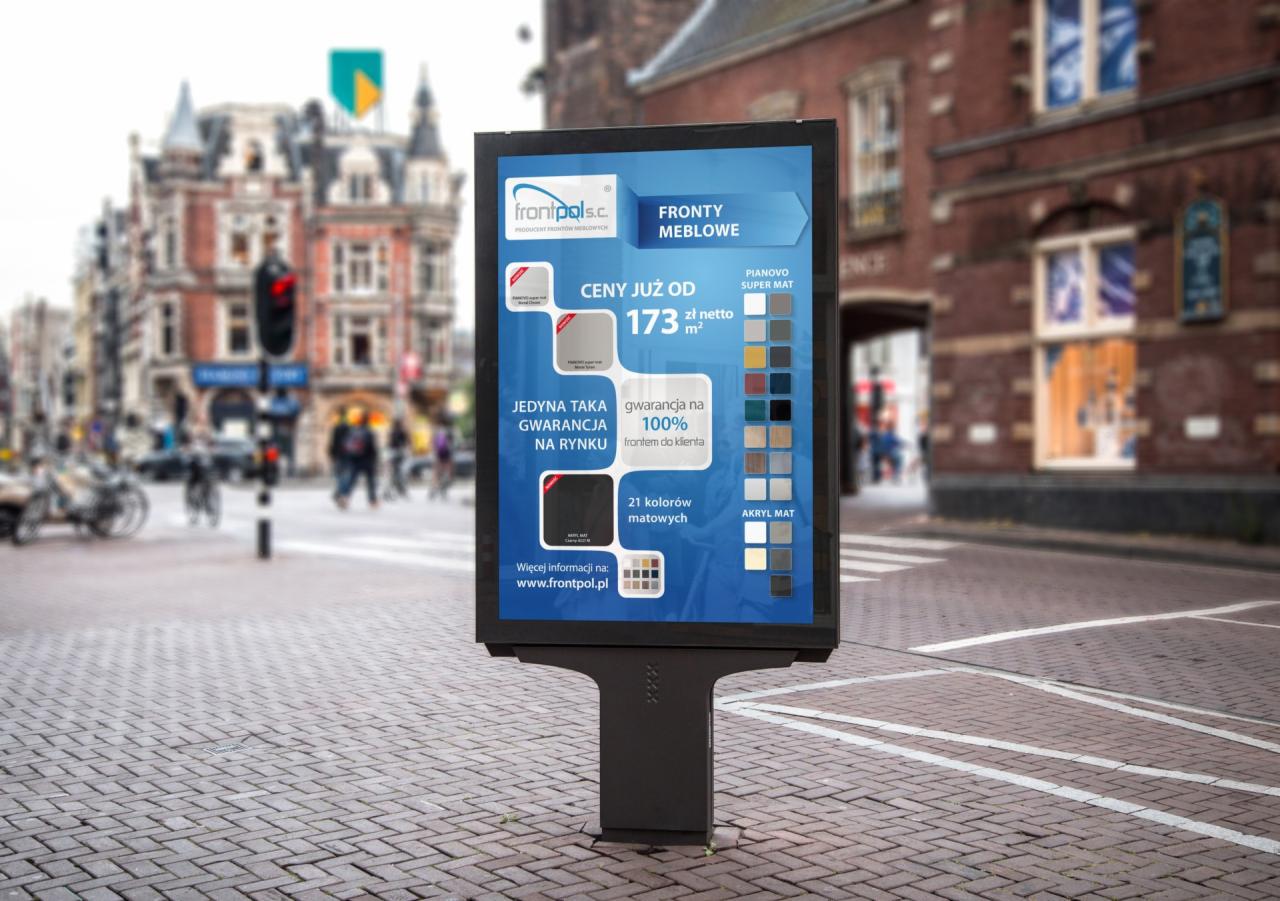 Billboard reklamujący fronty meblowe firmy frontpol.pl z ceną od 173 zł netto za m2, prezentujący paletę 21 kolorów matowych w odcieniach szarości, brązu i granatu na tle miejskiej ulicy...