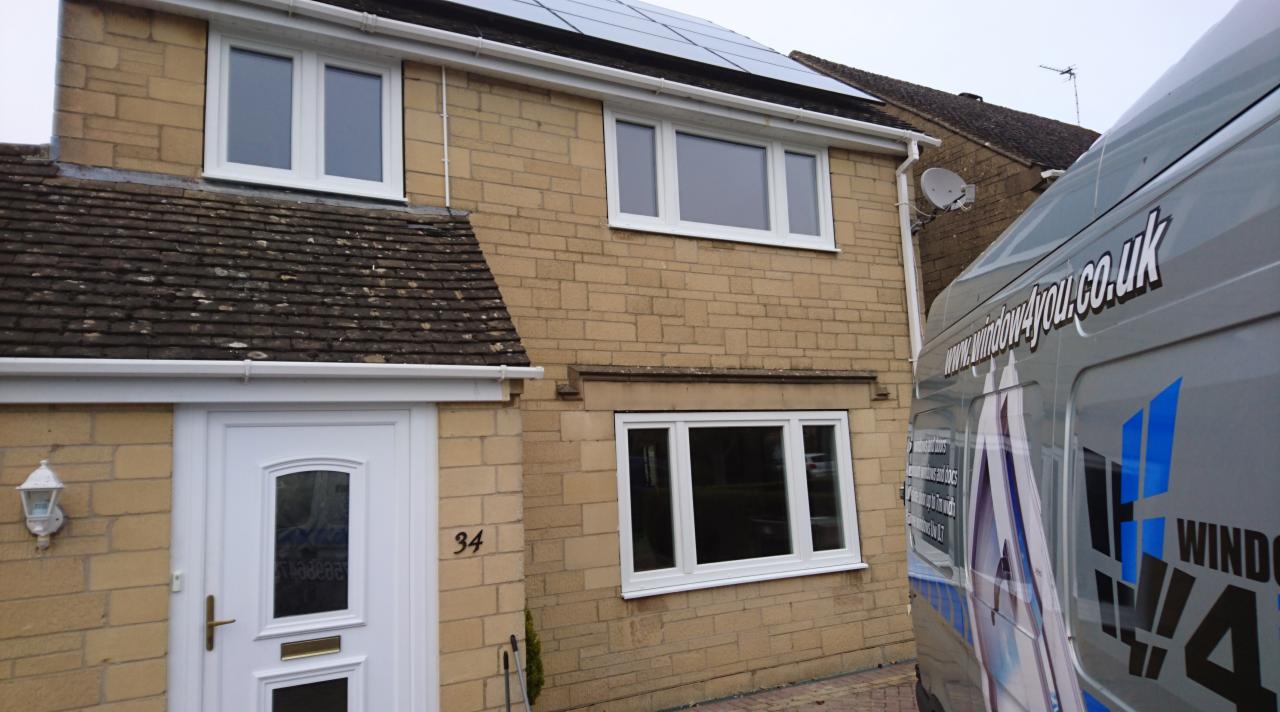 Dom z nowymi białymi oknami PCV i drzwiami wejściowymi, widoczny samochód dostawczy firmy 'window4you.co.uk' z boku.
