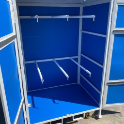 ADAM KUBALA - Otwarta metalowa szafa na kółkach z niebieskim wypełnieniem, widoczne uchwyty na narzędzia.