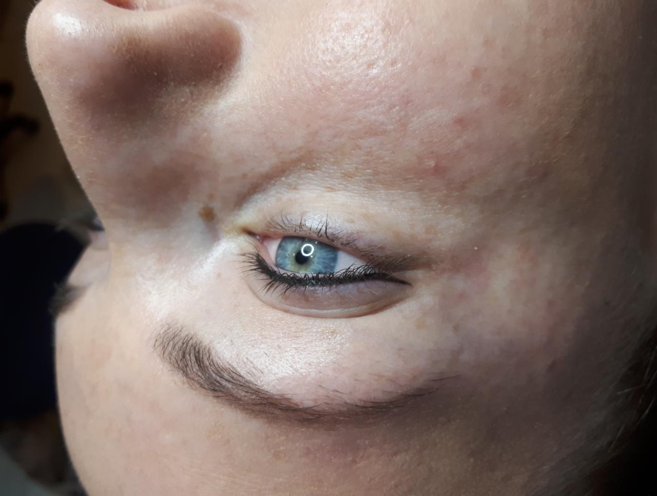 Zbliżenie na oko z delikatną kreską permanentną, podkreślającą linię rzęs, widoczne drobne niedoskonałości skóry.