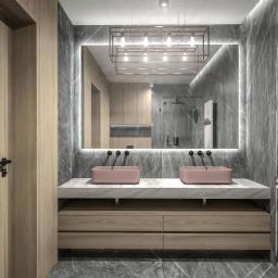 YOR - Nowoczesna łazienka z marmurowymi ścianami, podwójną umywalką w kolorze pudrowego różu, podświetlanym lustrem i drewnianymi szafkami pod umywalką.