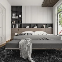 Nowoczesna sypialnia z łóżkiem, szarą narzutą i dywanem z długim włosiem, zabudową meblową z półkami i szafkami oraz dużym oknem z widokiem na zieleń.