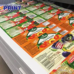 Arkusze z powtarzalnymi etykietami na dżemy owocowe, widoczne logo producentów dżemów i informacje o składzie, ułożone warstwami.