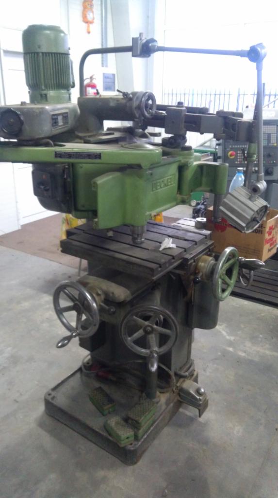 Zielona frezarka pionowa Becker z licznymi pokrętłami i pedałami, stojąca w warsztacie, z widocznym silnikiem i elementami mocującymi.