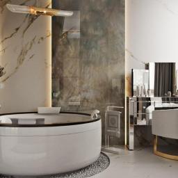Justyna Tatys Luxury Interiors - Elegancka łazienka z okrągłą wanną na kamiennym podłożu, podświetlane półki z kosmetykami i toaletka z lustrami w stylu glamour.