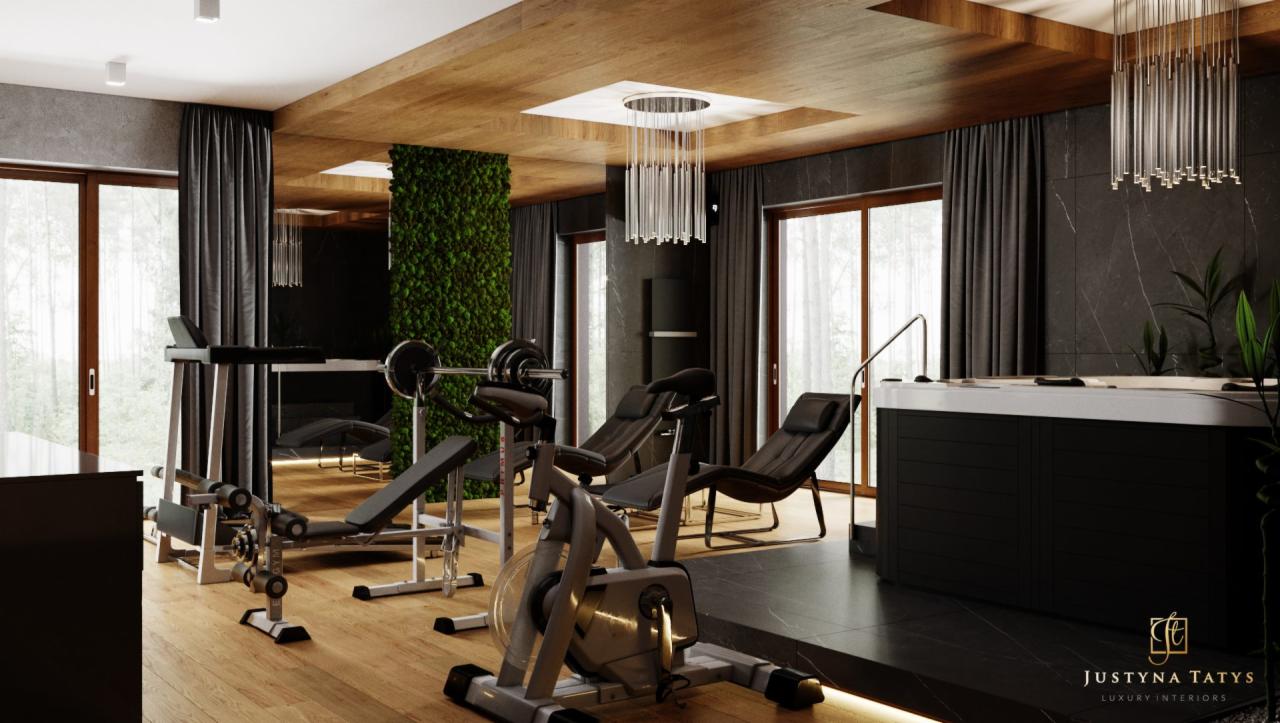 Nowoczesna domowa siłownia z jacuzzi, drewnianym sufitem i ścianą z zielonego mchu, oświetlona wiszącą lampą z rurek.