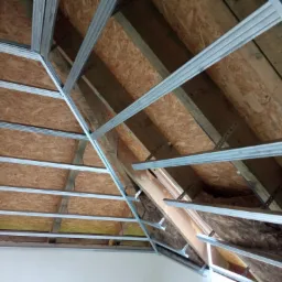 Szkielet metalowy pod płytę karton gips na poddaszu, widoczne ocieplenie wełną mineralną, konstrukcja drewniana dachu.