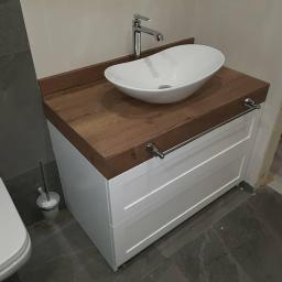 Twój Stolarz - Biała szafka łazienkowa z drewnianym blatem, nablatową umywalką i relingiem na ręczniki, widok z boku.