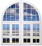 Białe, łukowe okno z widokiem na plażę i niebo odbijające się w szybach. Delikatne refleksy światła na powierzchni szkła.