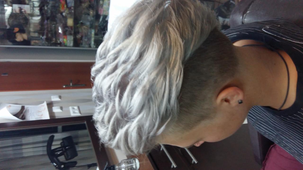 Krótkie, srebrzyste włosy z wygolonym bokiem, widok z boku, delikatne fale.