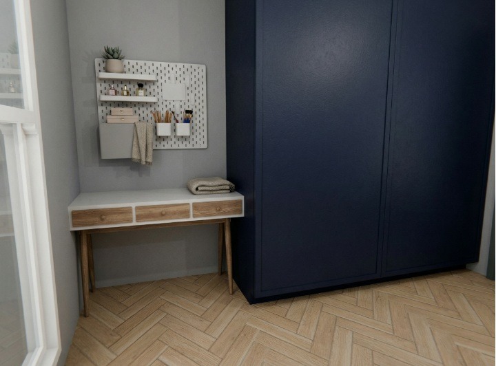Nowoczesny kącik z biurkiem z szufladami, pegboardem z akcesoriami i ciemnoniebieską szafą. Parkiet w jodełkę dodaje ciepła wnętrzu.