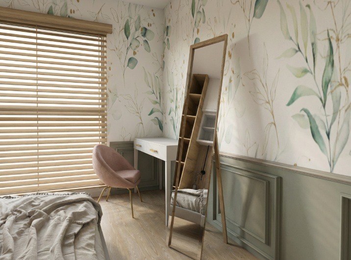 Pokój z toaletką, lustrem z półkami i tapetą w liście. Krzesło obite różowym welurem. Drewniane żaluzje w oknie. Częściowo widoczne łóżko z szarą narzutą.