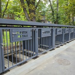 RAMIRES - Szary metalowy system pojemników na odpady segregowane: plastik i metal, papier, szkło, zmieszane; na zewnątrz, z zielenią w tle.